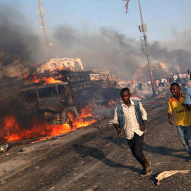 Varias personas huyen de la zona del atentado con camiones bomba contra un hotel y un mercado en MOgadiscio. REUTERS/Feisal Omar