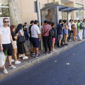 Numerosas personas guardan cola para subir al autobús tras el colapso de la red de Cercanías de Madrid, a 3 de agosto de 2023