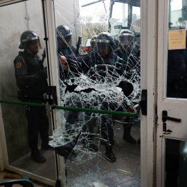 La Policía destroza la puerta del colegio electoral donde tenía que votar Carles Puigdemont./ REUTERS