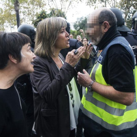 La alcaldesa de L'Hospitalet de Llobregat, Nuria Marin, se enfrenta a un policía fuera de la Escuela Can Vilumara. EFE/Quique García