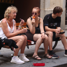 Tres turistes es mengen un gelat al carrer de Santa Clara de Girona