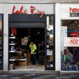 Un empleado de una tienda en el centro de Madrid limpia la entrada del establecimiento. REUTERS