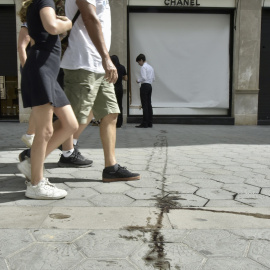 Varias personas caminan frente al escaparate de la tienda de Chanel que ha sufrido esta madrugada un intento de robo, a 7 de agosto de 2023, en Barcelona, Catalunya (España).