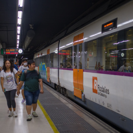 11/08/2023 Viajeros al lado de un tren en uno de los andenes de la estación de Sants