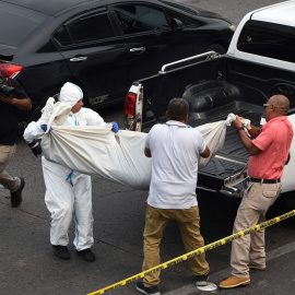 El personal de medicina forense traslada el cuerpo de uno de los jóvenes asesinados a tiros por pandilleros en las inmediaciones de un centro comercial en Tegucigalpa el 26 de abril de 2023.