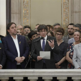 El presidente de la Generalitat, Carles Puigdemont (c) junto al vicepresidente del Govern y conseller de Economía, Oriol Junqueras y la presidenta del Parlament, Carme Forcadell, realiza una declaración en las escalinatas del Parlamen del Parlament tras