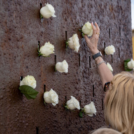 Varias personas depositan flores en el monumento por las víctimas durante la ofrenda floral por el 15º aniversario de la tragedia de Spanair, a 20 de agosto de 2023, en Las Palmas de Gran Canaria.