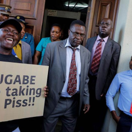 Manifestantes protestan mientras los diputados asisten a la sesión parlamentaria en Harare. | KIM LUDBROOK (EFE)