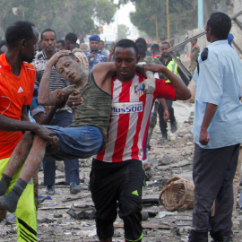 Ciudadanos asisten a un hombre, herido tras la explosión de un coche bomba en Somalia. REUTERS/Feisal Omar