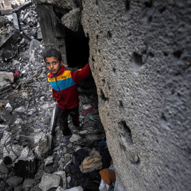 8/3(24 - Un niño palestino se encuentra entre los escombros de una casa destruida tras un ataque aéreo israelí, en Deir Al Balah, al sur de la Franja de Gaza, el 8 de marzo de 2024