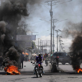 Un hombre pasa junto a una barricada en llamas durante una protesta en Puerto Príncipe (Haití) el 7 de marzo de 2024.