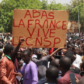 Varios manifestantes sostienen un cartel que dice "Abajo Francia, larga vida al CNSP" durante una marcha en apoyo de los golpistas en Niamey, a 30/07/2023.