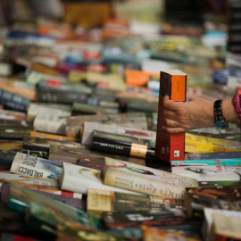 Un hombre compra un libro en un puesto de libros de las Ramblas de Barcelona durante la diada de Sant Jordi. (ENRIC FONTCUBERTA | EFE)