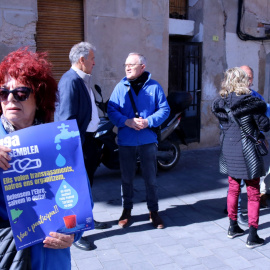 Una activista de la PDE morta un cartell de la 19a assemblea de l'entitat, amb representants del movimebnt social, econòmics i polítics parlant davant la delegació de la Generalitat, a Tortosa