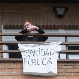 Una vecina coloca una pancarta que reza 'Sanidad Pública' para apoyar una manifestación por la sanidad pública en Villa de Vallecas, a 5 de marzo de 2023, en Madrid (España).