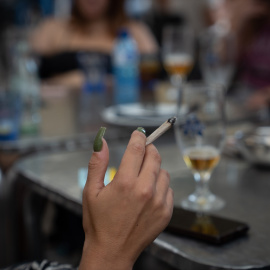 Una mujer fuma sentada en la mesa de una terraza de Barcelona, a 23 de septiembre de 2022.