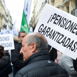 Un hombre con una pancarta que reza '¡Pensiones garantizadas!' en una marcha por el blindaje de las pensiones en Madrid. E.P./Gustavo Valiente