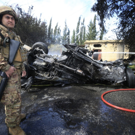 Un bombero apaga un automóvil en llamas atacado por un dron israelí en Al Hoash Road, en el sur del Líbano, el 13 de marzo de 2024.