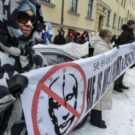 Manifestantes sostienen una pancarta con una imagen tachada de Vladimir Putin en Helsinki, Finlandia, el 17 de marzo de 2024.