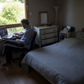 Un hombre teniendo una conferencia online en su habitación.