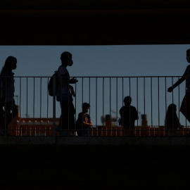 Varios alumnos en el patio de un colegio.