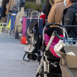 Varias personas hacen cola para recibir alimentos de la Fundación Madrina, en la plaza de San Amaro, a 7 de enero de 2022, en Madrid (España).