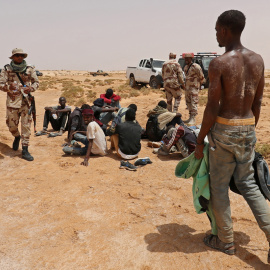 Un grupo de migrantes subsaharianos el asistido por militares libios después de que las autoridades de Túnez los trasladaran forzosamente al desierto y fueran abandonados sin agua ni comida el pasado julio.