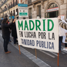 22/09/23-Dos personas sujetan una pancarta durante una cacerolada frente a la sede de la Dirección General de Recursos Humanos del Servicio Madrileño de Salud, a 22 de marzo de 2023, en Madrid.