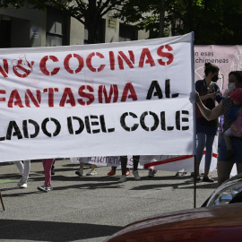 Varias personas participan en la manifestación contra la instalación de 'cocinas fantasma' en zonas residenciales y escolares del distrito madrileño de Arganzuela este sábado.