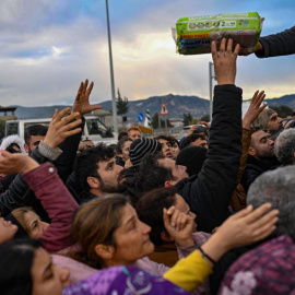 Supervivientes del terremoto en Turquía tratan de alcanzar suministros el 7 de febrero de 2023, en la provincia de Hatay.