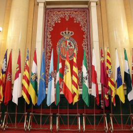 La bandera de España y las distintas banderas autonómicas colocadas en el antiguo salón de plenos del Senado. EFE/Javier Lizón