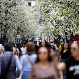 Varias personas pasean junto a árboles en flor durante el primer día de primavera, a 20 de marzo de 2024, en Madrid.