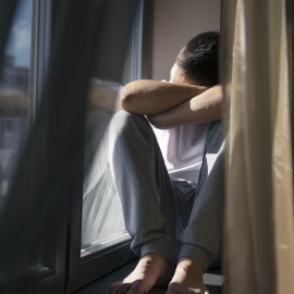 Retrato de un hombre con cortinas y sombras desde la ventana