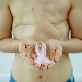 Una mujer sostiene el lazo rosa, símbolo de la lucha contra el cáncer de mama.