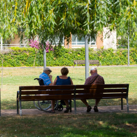 Foto de archivo de tres ancianos en el patio de una residencia, a 9 de agosto de 2023.