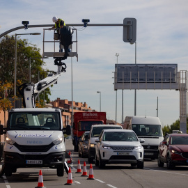 Un técnico monta una cámara de tráfico en un semáforo para controlar el acceso a la Zona de Bajas Emisiones (ZBE) de Madrid.