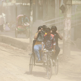 La contaminación del aire impide a un grupo de jóvenes circular por un camino de tierra en Dhaka, Bangladesh, a 5 de julio de 2023.