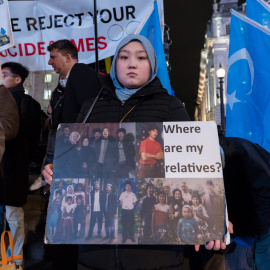 Una mujer uigur sostiene un cartel con fotografías de sus familiares, en una protesta en Piccadilly Circus, a 3 de febrero de 2022 en Londres, Inglaterra.