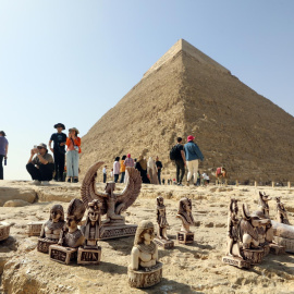 Pequeñas figuritas "souvenirs" descansan en el suelo junto a las pirámides de Guiza ante los ojos de decenas de turistas este 2 de marzo de 2023.