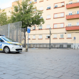 Dos personas mayores pasan junto a un coche de policía municipal, a 22 de octubre de 2022, en Madrid.