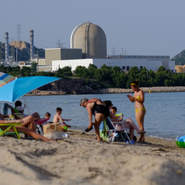 La central nuclear Vandellós II se ve al fondo mientras la se baña en la playa de la Almadraba en Hospitalet del Infante, en Tarragona.