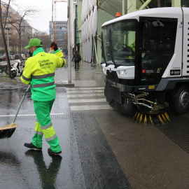 Un treballador netejant a la superilla del Poblenou de Barcelona, juntament amb una de les màquines de la nova flota de vehicles.