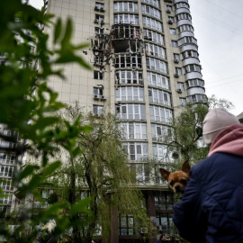 Una mujer mira un bloque de apartamentos dañado por los escombros de la explosión de un dron ruso en Kiev, Ucrania, el 8 de mayo de 2023.