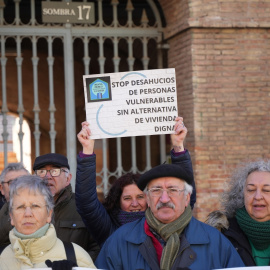 Una mujer levanta una pancarta de 'Stop desahucios' durante una concentración de la Plataforma de Afectados por la Hipoteca (PAH) .