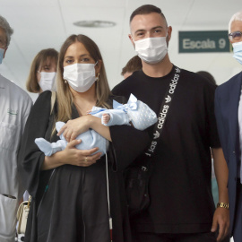 La pareja formada por Tamara y Jesús posan con el conseller de Salud, Manel Balcells (d), el jefe del servicio de Ginecología del Hospital Clínic, Francisco Carmona (i), y su hijo, el pequeño Jesús.