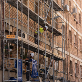 Un trabajador subido a los andamios de una obra, a 17 de mayo de 2023, en Barcelona.