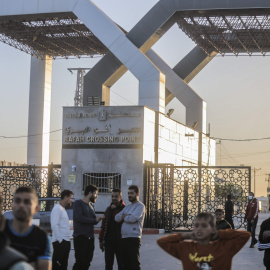 Varios palestinos se reúnen frente al paso fronterizo de Rafah para esperar el paso de los vehículos que transportan rehenes israelíes desde la Franja de Gaza a Egipto, a 24/11/2023