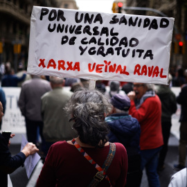 Una mujer sujeta un cartel de protesta durante una manifestación contra la privatización de la sanidad, a 7 de abril de 2024, en Barcelona, Catalunya (España).