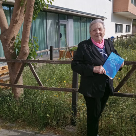 Criselda Flores posa con sus memorias en el jardín de la residencia de mayores donde vive.