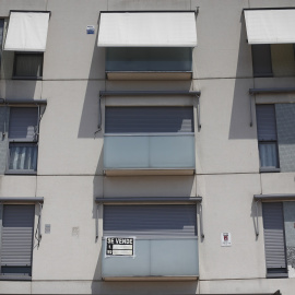 Cartel de se vende en el balcón de un piso de un edificio de Madrid.